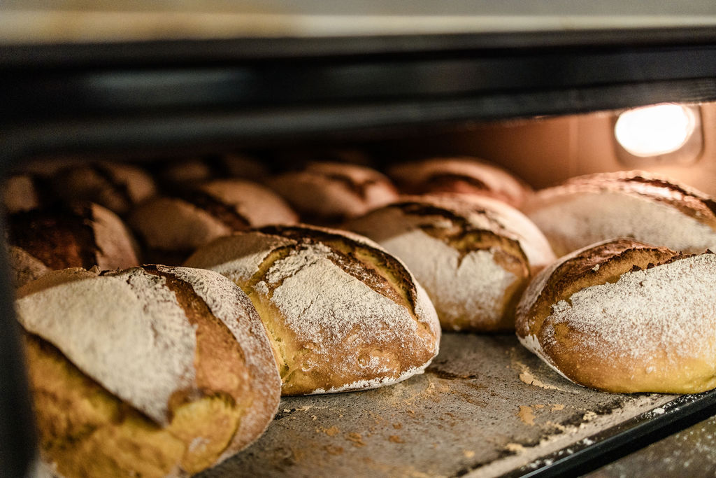 Frische Bauernbrote mit bemehlter Kruste im Ofen
