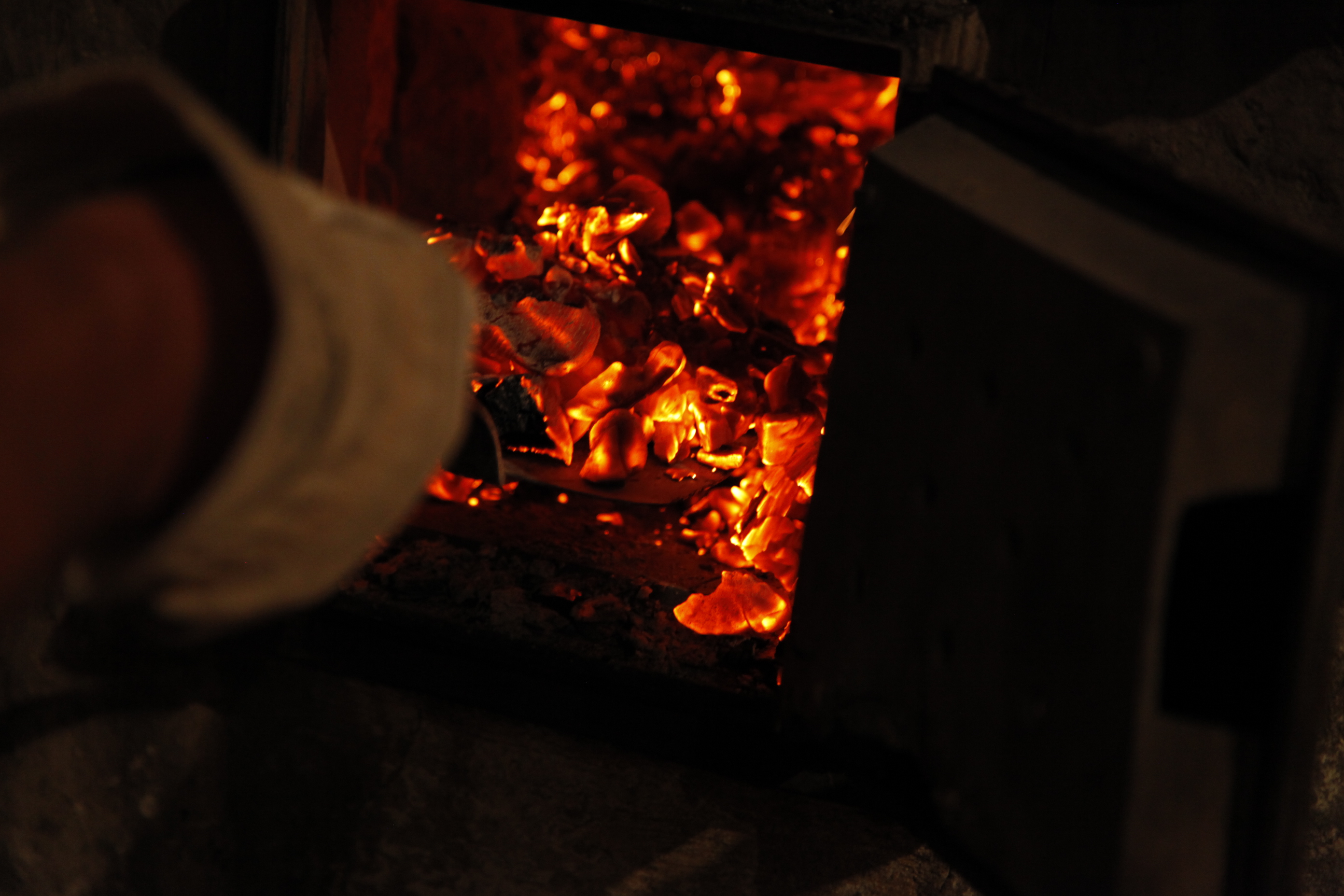 Blick in den glutroten Holzofen mit Schieber
