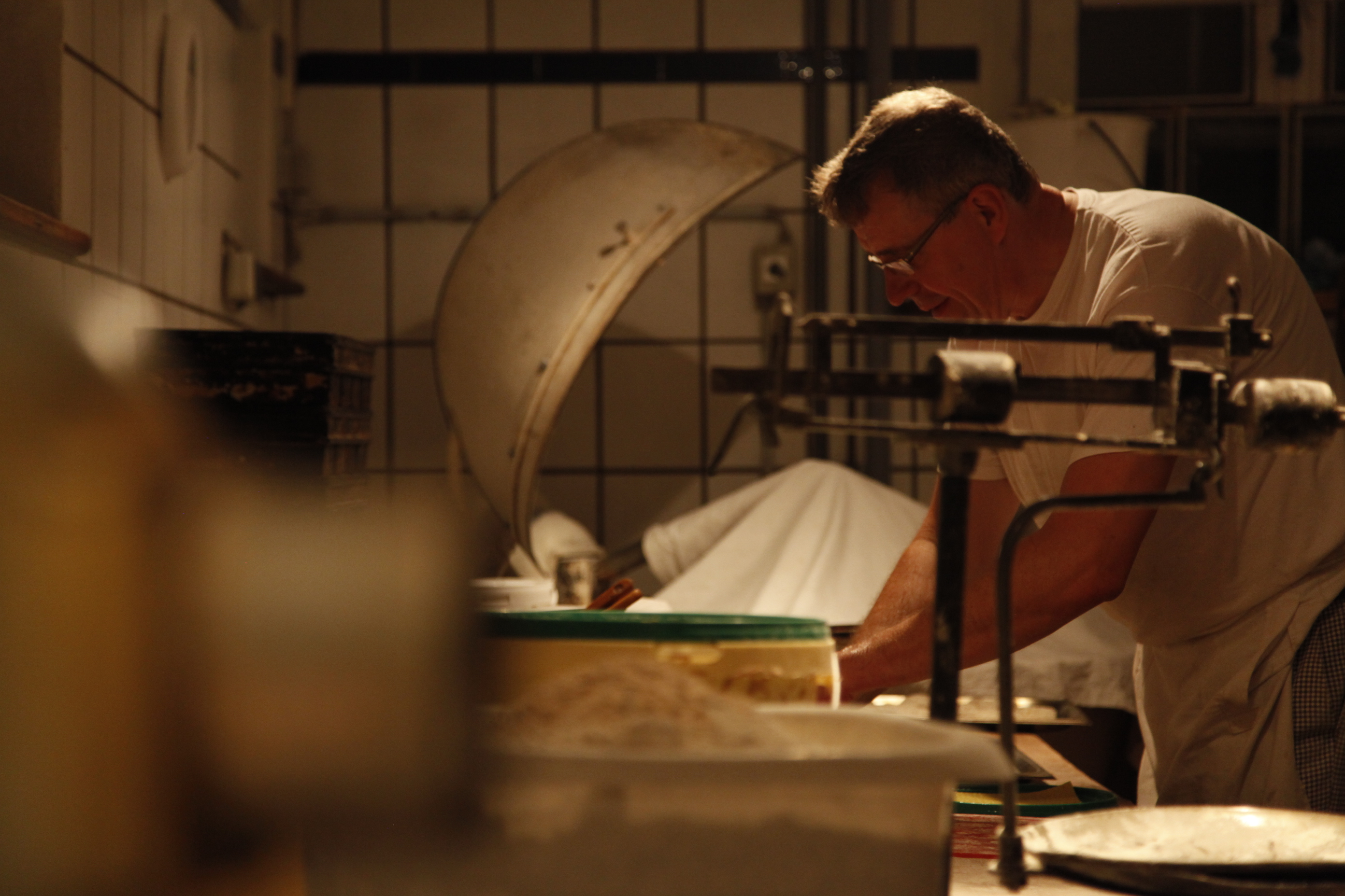 Hände bemehlen frisch geformte Teiglinge auf dem Tisch