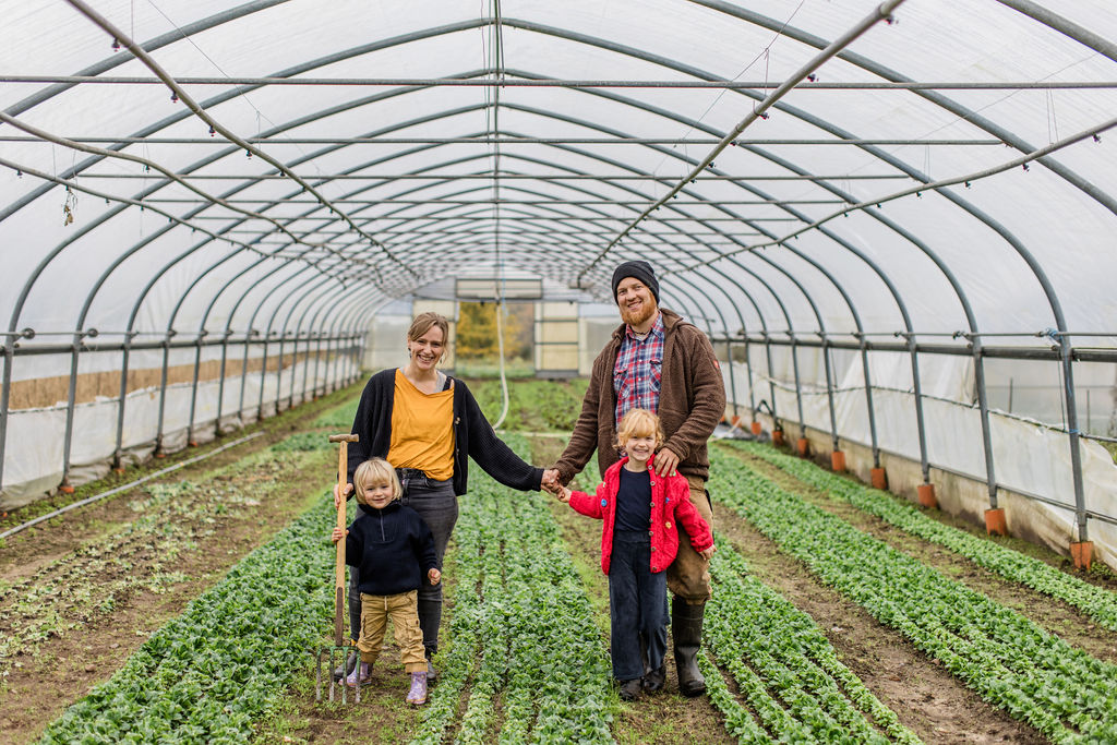 Kind mit frisch geerntetem Lauch auf dem Feld