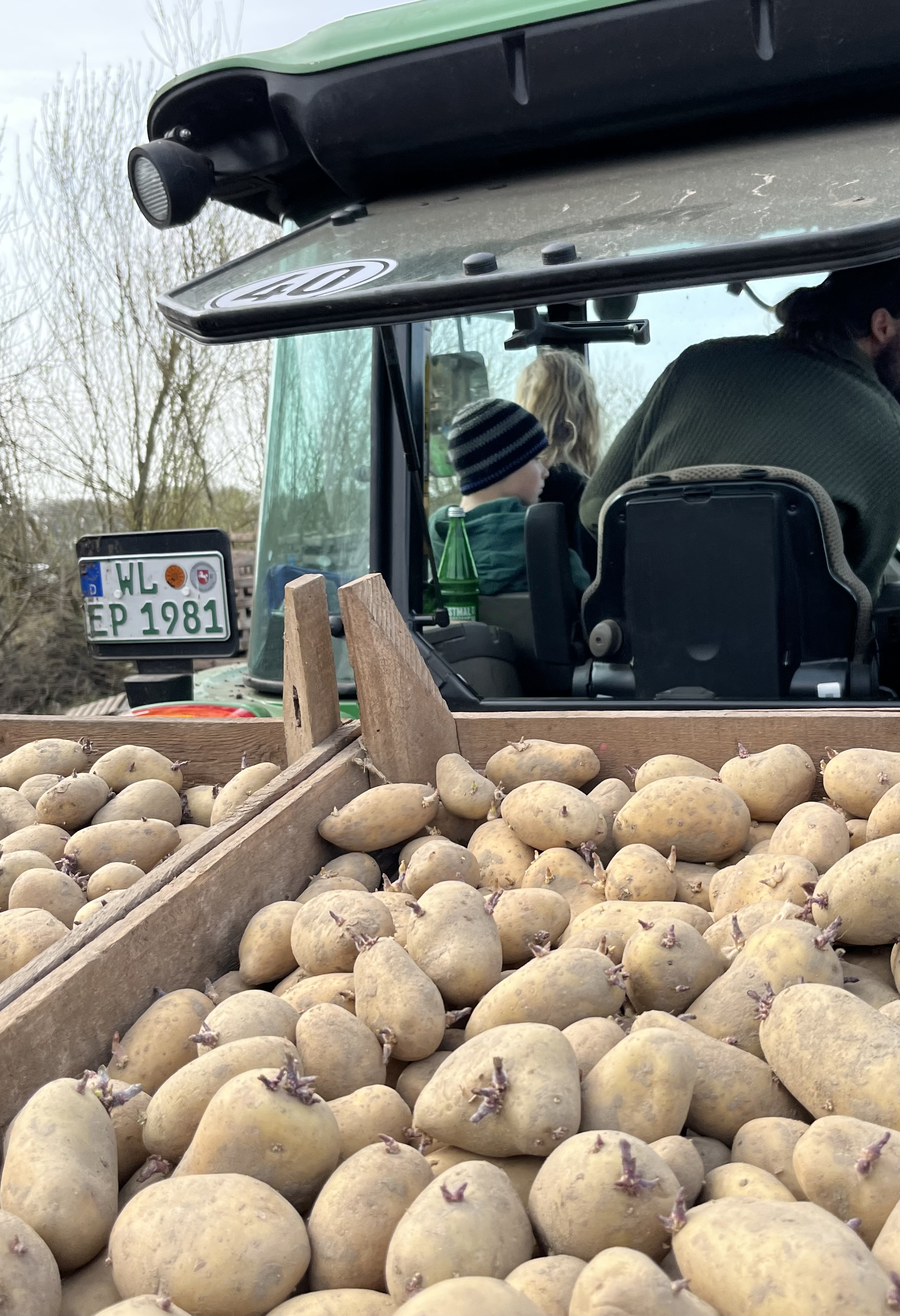 Pflanzkartoffeln auf der Pflanzmaschine, Familie im Traktor