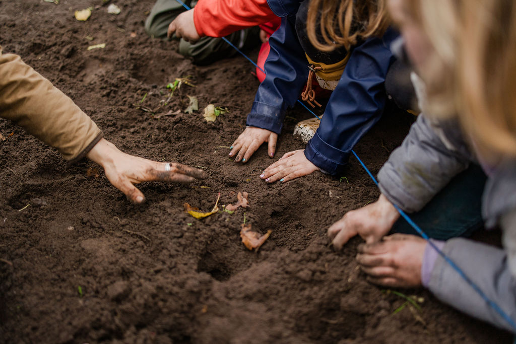 Pädagogik – Kinderhände in der Erde beim Pflanzen